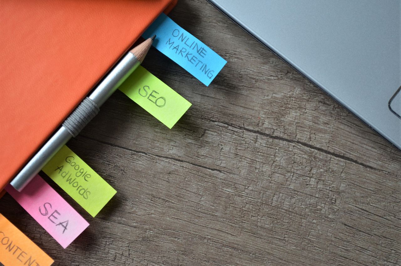 services-04 Close-up of SEO strategy planner with colorful sticky notes and a pencil on a notebook.